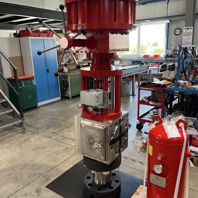 Gro&szlig;es rotes Ventil mit Druckbeh&auml;lter in einer Industriewerkstatt auf schwarzer Bodenmatte. | Copyright: PROVALVE Armaturen GmbH & Co. KG