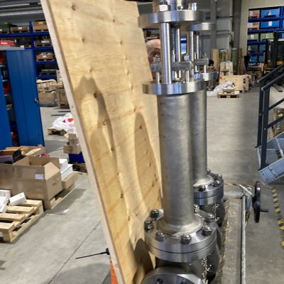 Gro&szlig;e metallische Faltenbalgarmature mit Stahlgeh&auml;use und Anschl&uuml;ssen in einer Werkstatt, neben einer Holzplatte positioniert. | Copyright: PROVALVE Armaturen GmbH & Co. KG