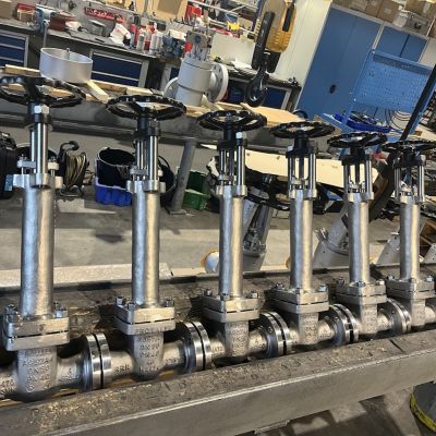 Mehrere Faltenbalgarmaturen mit Ventilk&ouml;rpern und Stellantrieben auf einer Werkbank in einer Industriewerkstatt. | Copyright: PROVALVE Armaturen GmbH & Co. KG