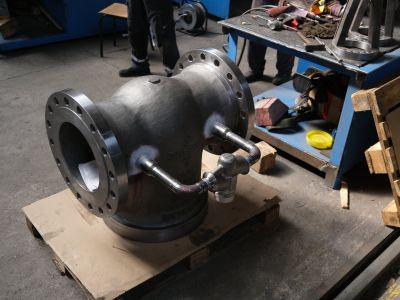 Gro&szlig;es schwarzes Stahlventil mit Flanschen auf einer Holzpalette in einer Produktionswerkstatt. | Copyright: PROVALVE Armaturen GmbH & Co. KG