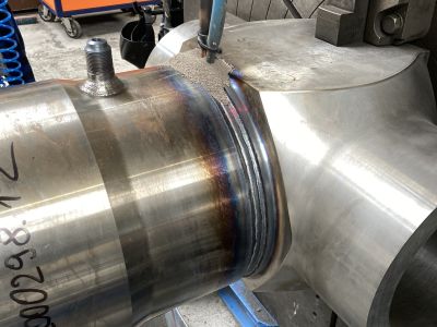 Gro&szlig;e metallische Ventilkomponente wird auf einer Drehmaschine bearbeitet, mit einer orangen Steuerungsanlage im Hintergrund. | Copyright: PROVALVE Armaturen GmbH & Co. KG